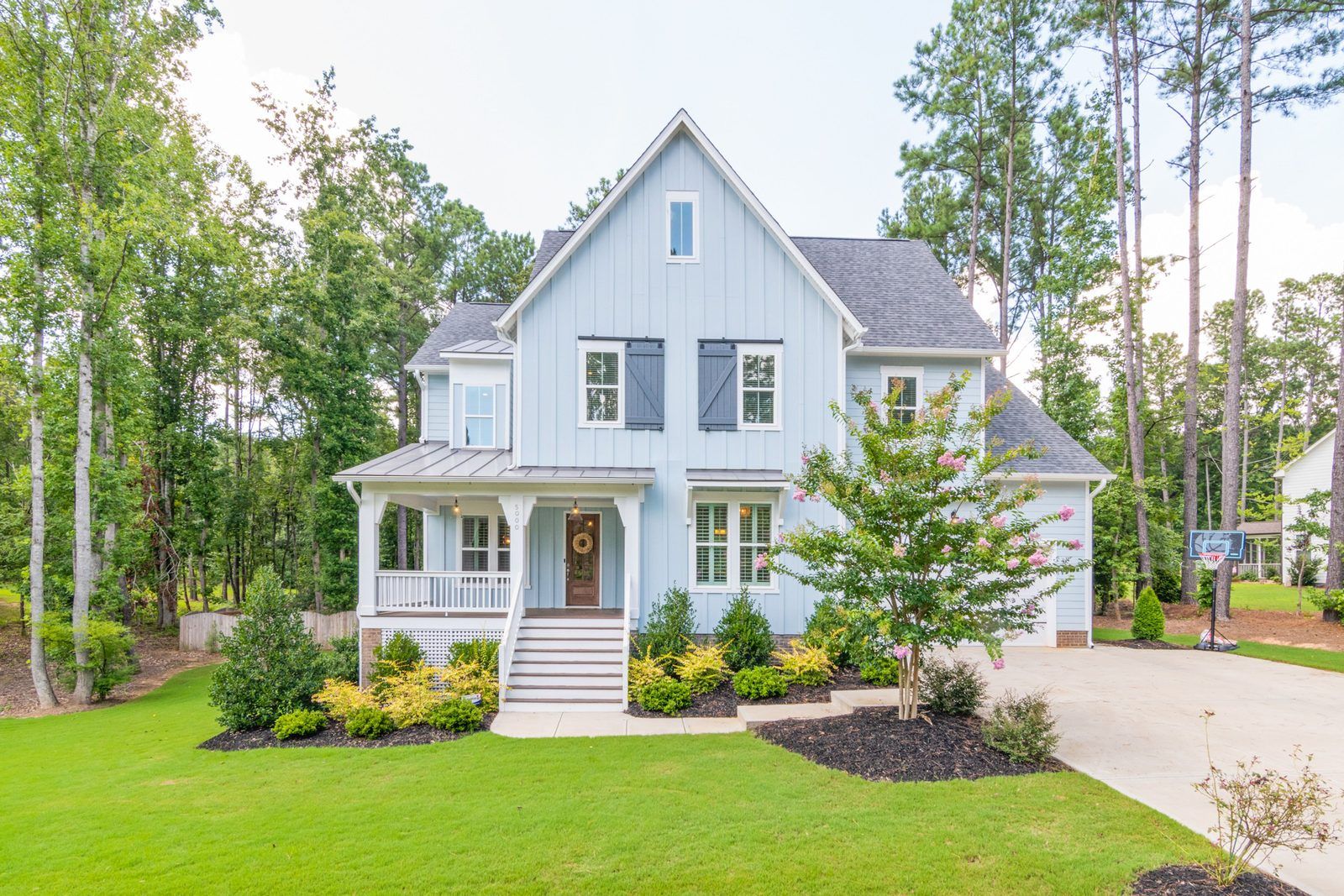 Two-story home with a front porch on a quiet, tree-lined residential street